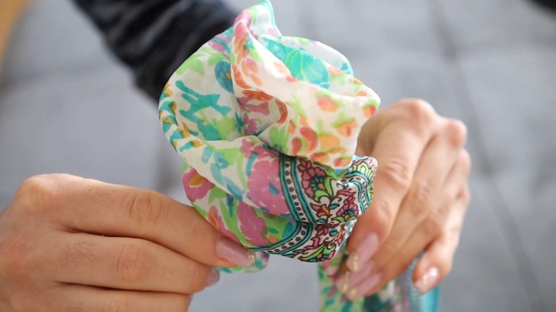 A colorful floral scarf tied into a rose