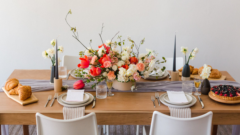 Dinning table with plates, centerpiece, and table runner