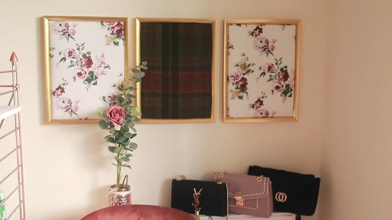 Three picture frames with fabric art hung on the wall