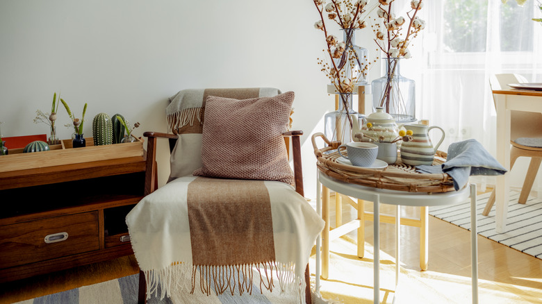 A chair decorated with a scarf and pillow