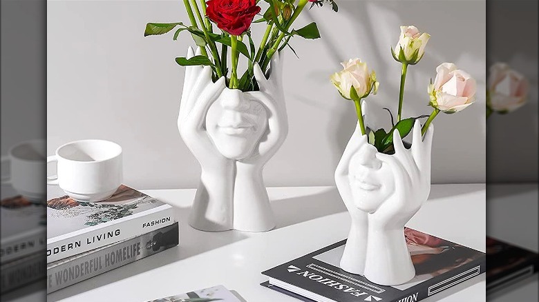 White face-shaped vases with roses