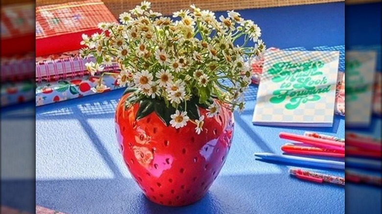 Strawberry-shaped vase with daisies