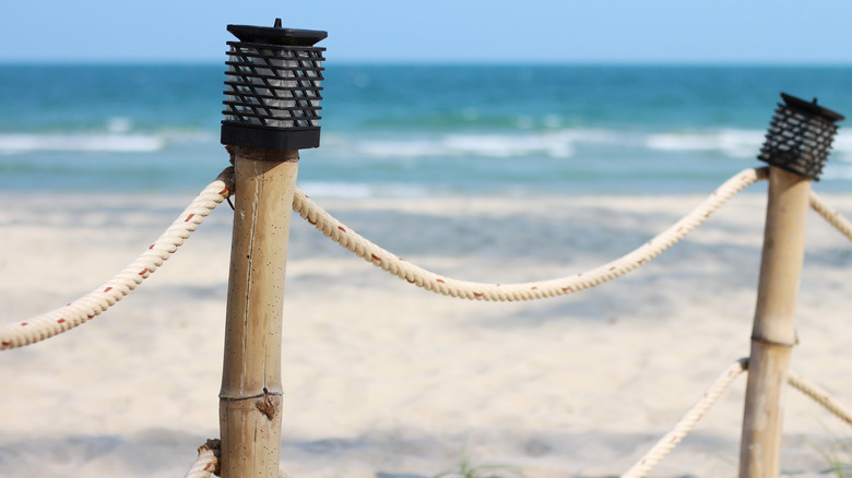 lights on top of rope fence near beach