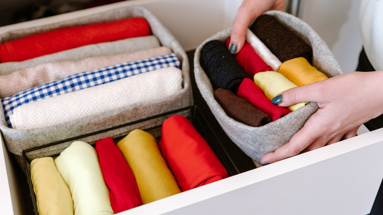 person putting clothes in organizers