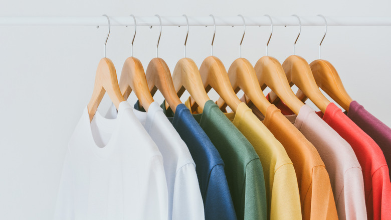 wooden hangers with colorful shirts