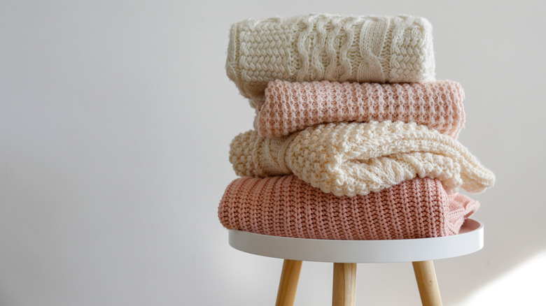 folded sweaters on small table