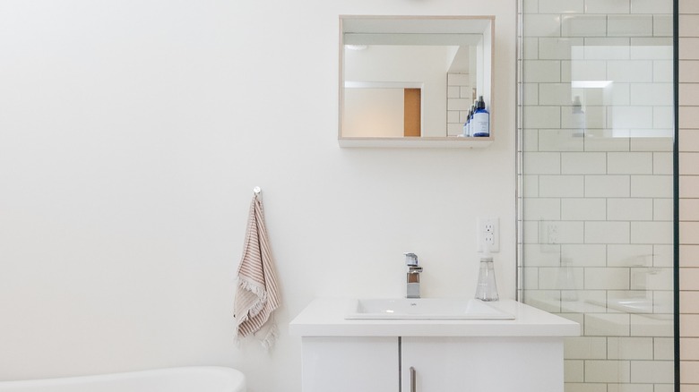 White bathroom with mirror shelf