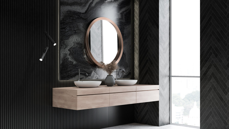 Dark bathroom with round mirror