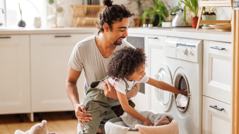 father doing laundry with son