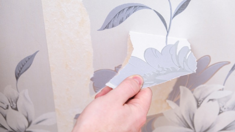 hand removing floral wallpaper