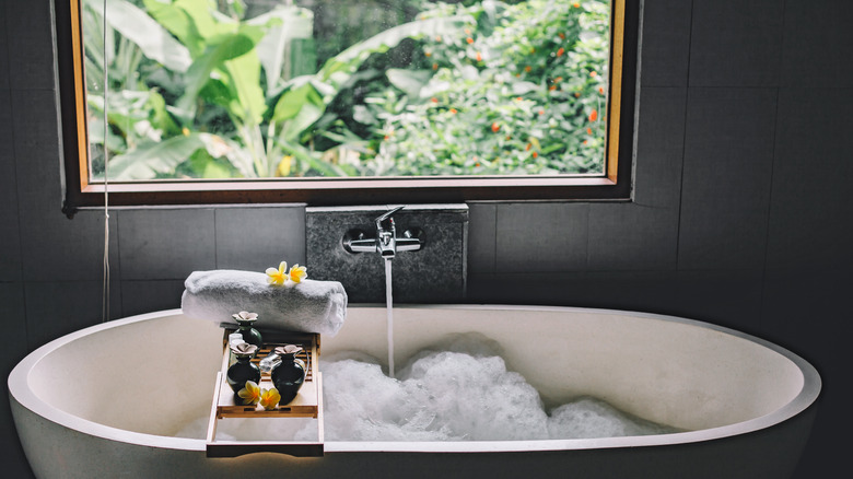 black window above white bathtub