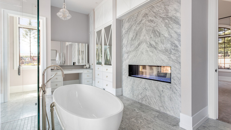 marble fireplace near white bathtub