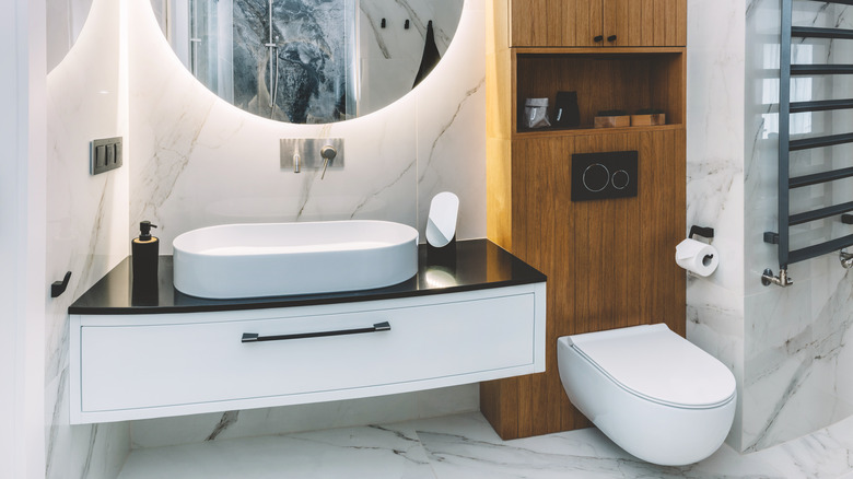 wooden cabinet behind white toilet