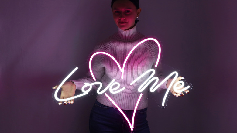 Woman holding neon love sign