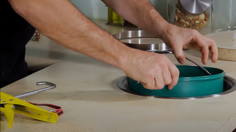 man installing countertop trash bin