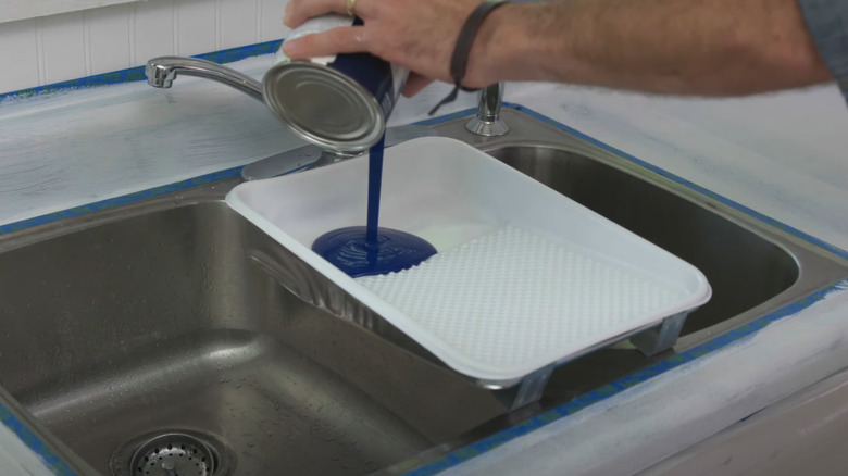 putting blue paint in tray