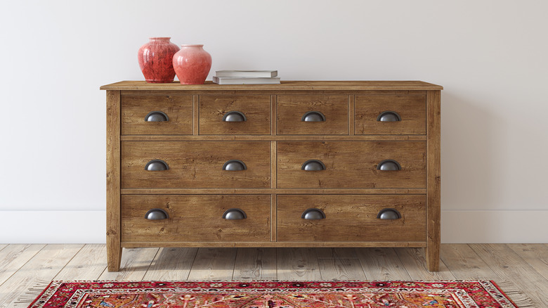 wooden dresser with red vases