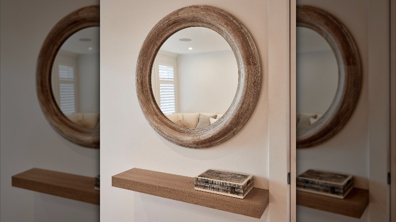 wooden shelf beneath round mirror