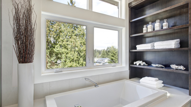 large shelves above white bathtub