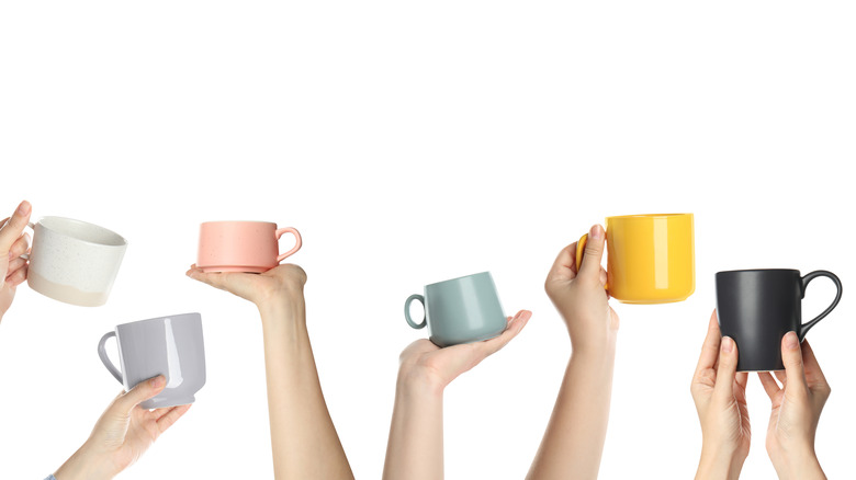 hands holding different mugs