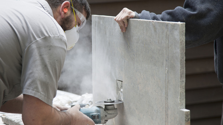 A man cuts slab of granite stone for countertop