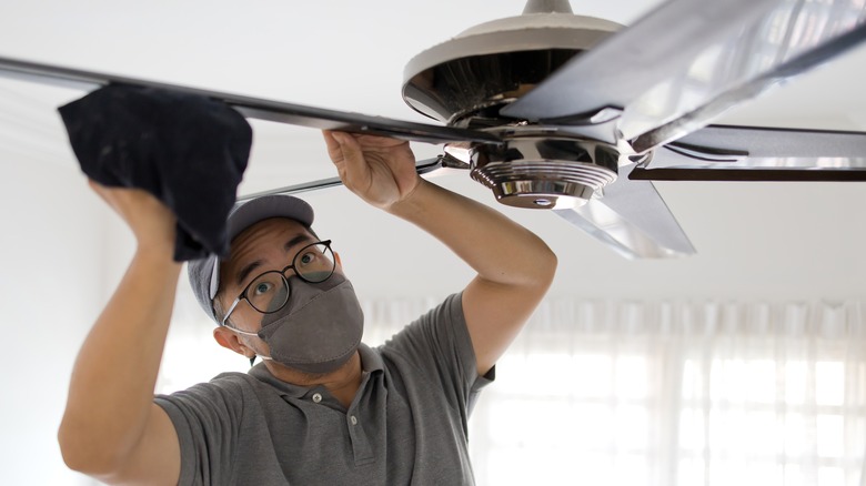 man cleaning a ceiling fan