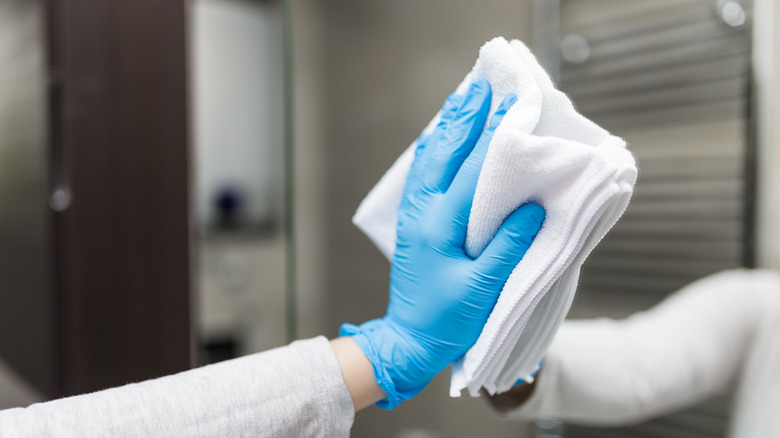 Person wiping a mirror