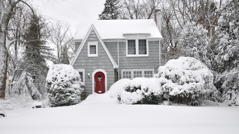 grey house with snow-covered roof 