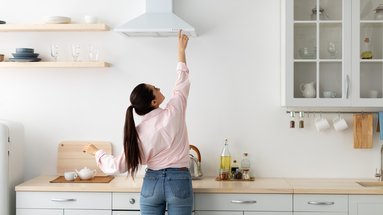 woman turning on exhaust fan