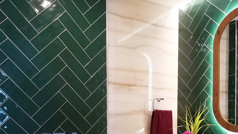 Bathroom mirror against green tile