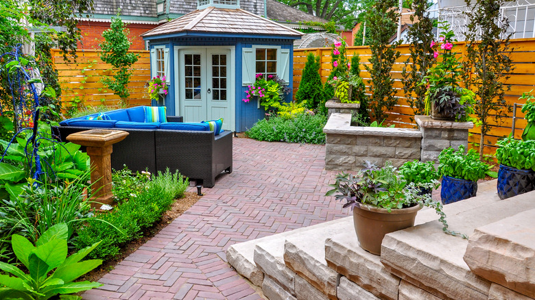 blue shed on brick patio