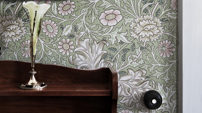 table in front of muted floral wallpaper