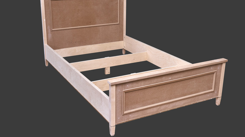 walnut plywood bed frame on dark background