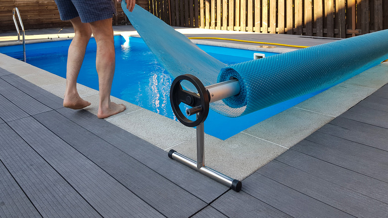 Man placing cover on pool