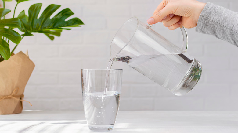 Hand pouring water from jug