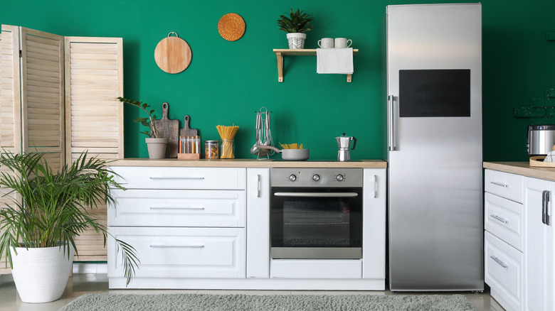 green wall behind white kitchen