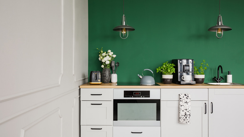 green wall behind white cabinets