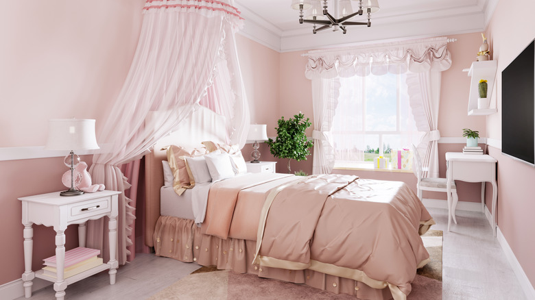 a pink bedroom with canopy