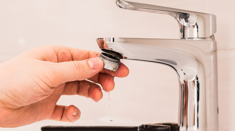 hand holding a faucet aerator