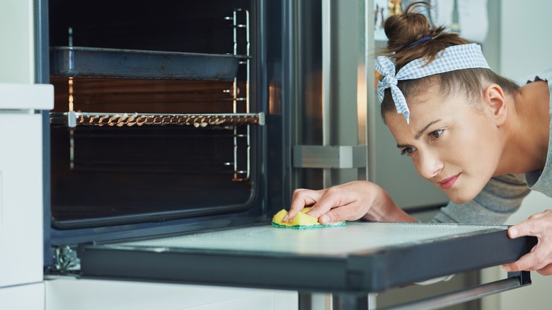 woman cleaning oven