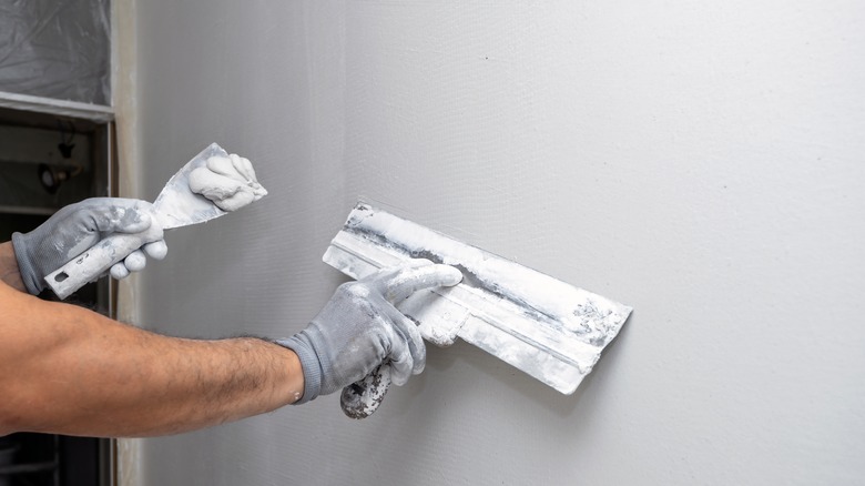 applying putty to wall