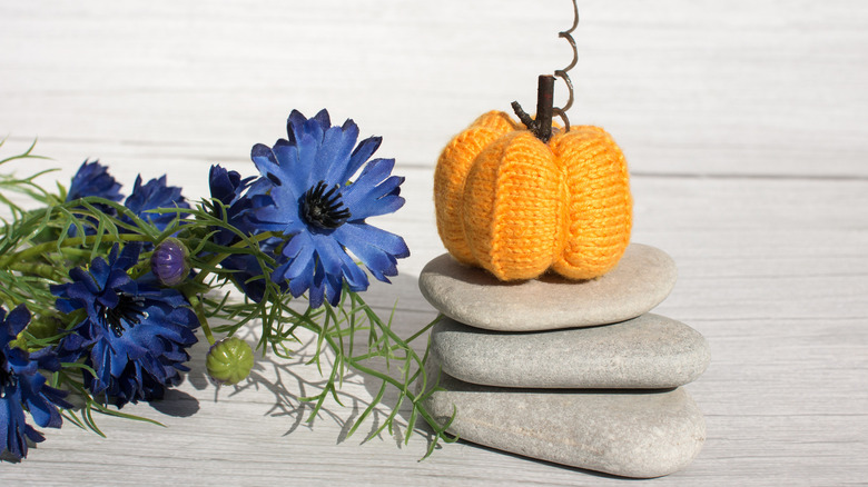 Knitted pumpkin on rocks