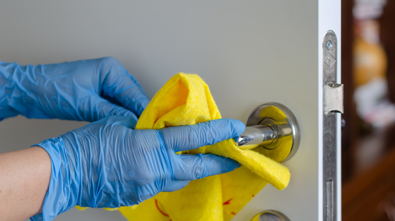 person cleaning door handle