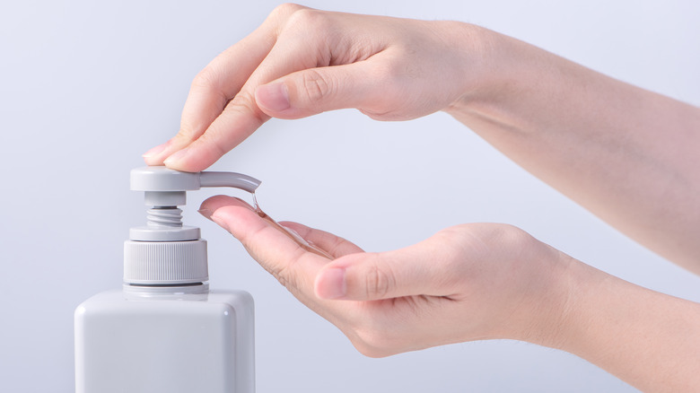 person using soap dispenser