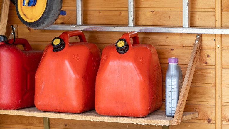 Gas cans on a wooden shelf