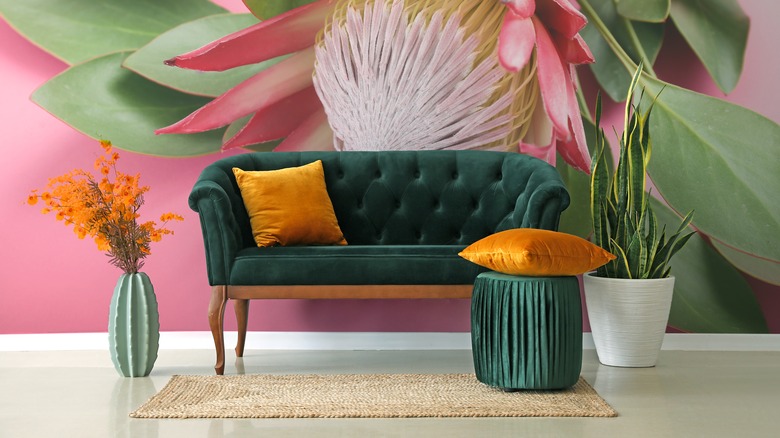 floral wallpaper behind green couch