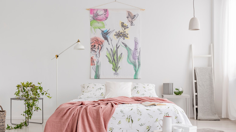 floral tapestry above bed