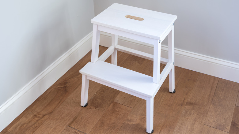 White step stool in room corner