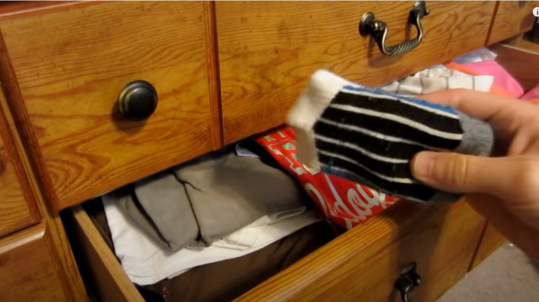 holding folded sock near drawer