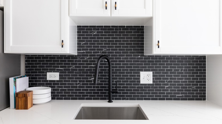 black backsplash with white cabinets